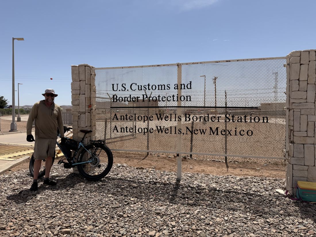 Joe and his bike at the Antelope Wells border station sign